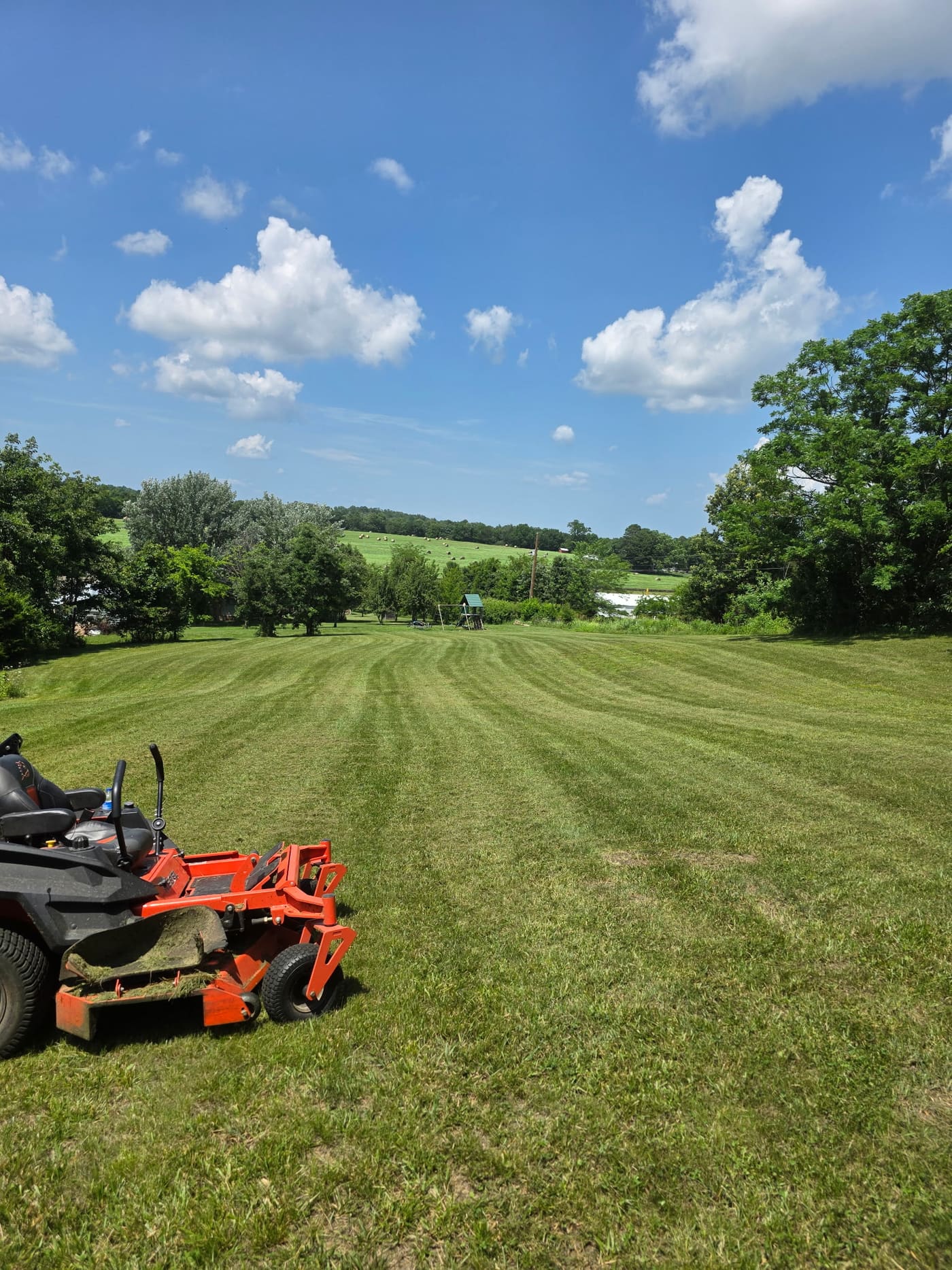 White Water Lawn Care zero-turn mower with fresh stripes on a lawn in Mountain View, Arkansas